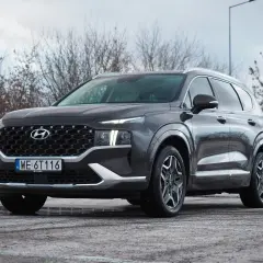 Ciemnoszary Hyundai Santa Fe z polskimi tablicami WE 6T116 stoi na parkingu.