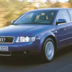 Niebieskie audi a4 b6 w ruchu, z rozmytym tłem drzew i drogi.