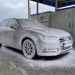 Szary Audi w pianie, gotowy do mycia samochodu na samoobsługowej myjni.