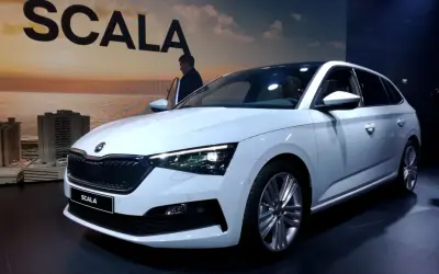 Biały skoda scala hatchback prezentuje się elegancko na tle miejskiego krajobrazu.