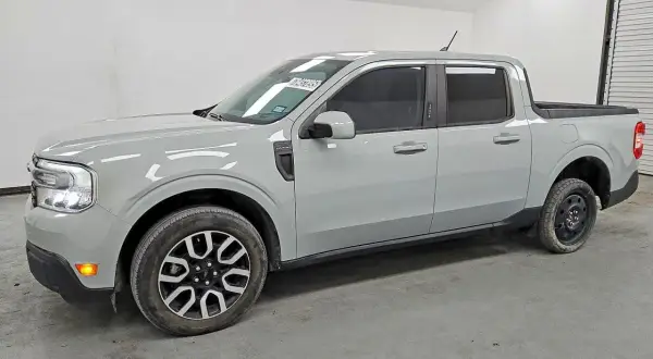 Szary Ford Maverick, kompaktowy pickup, stoi w garażu. Jego linia nadwozia jest nowoczesna, a przednie światła LED nadają mu charakterystyczny wygląd.