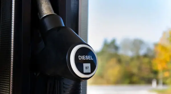 Dystrybutor paliwa z oznaczeniem DIESEL B7. W tle jesienne drzewa i błękitne niebo.