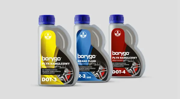 Trzy butelki płynu hamulcowego Borygo: DOT-3 (żółty), DOT-4 (czerwony) i jeden z oznaczeniem R-3/205 (niebieski).
