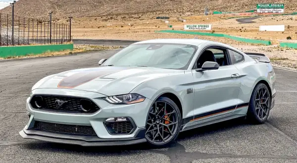 Jasnoszary Ford Mustang Mach 1 z pomarańczowymi akcentami na torze wyścigowym Willow Springs.