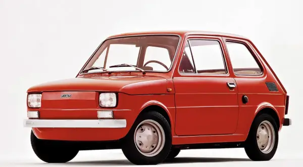 Czerwony fiat 126p, kultowy "maluch", prezentowany na białym tle.
