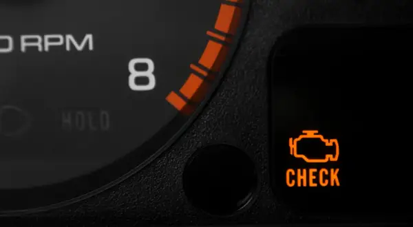 Pomarańczowa kontrolka **check engine** świeci się na desce rozdzielczej, obok wskaźnika obrotów.