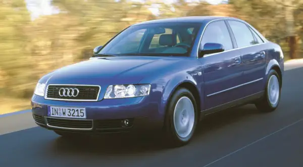 Niebieskie audi a4 b6 w ruchu, z rozmytym tłem drzew i drogi.
