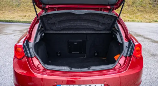 Bagażnik czerwonego Alfa Romeo Giulietta, gotowy na podróż.