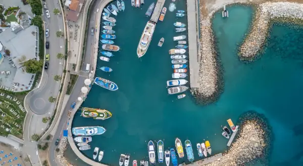 Port na Cyprze, gdzie ruch lewostronny widać na drodze obok zacumowanych łodzi.
