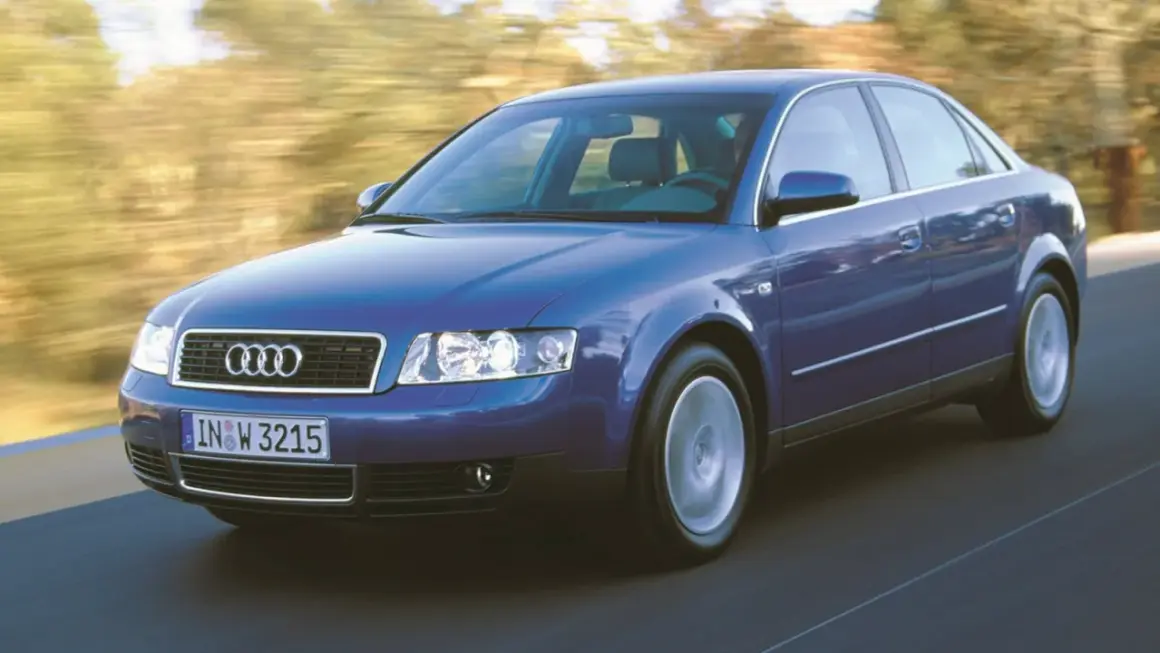 Niebieskie audi a4 b6 w ruchu, z rozmytym tłem drzew i drogi.