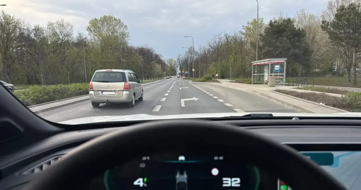 Jazda na suwak przepisy: samochód osobowy i minivan na drodze z pasami ruchu, jeden z nich wskazuje skręt w prawo.