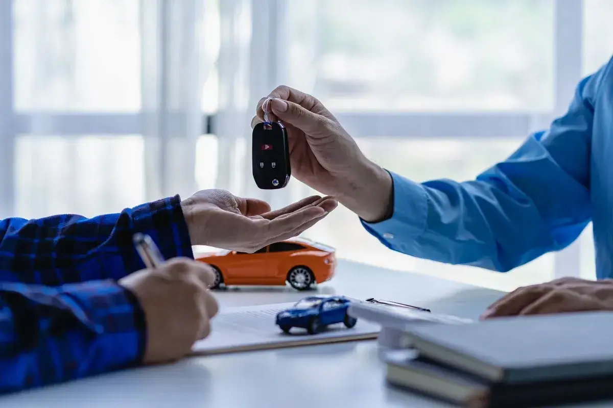 Przykładowy leasing samochodu: przekazanie kluczyków do nowego auta po podpisaniu umowy.
