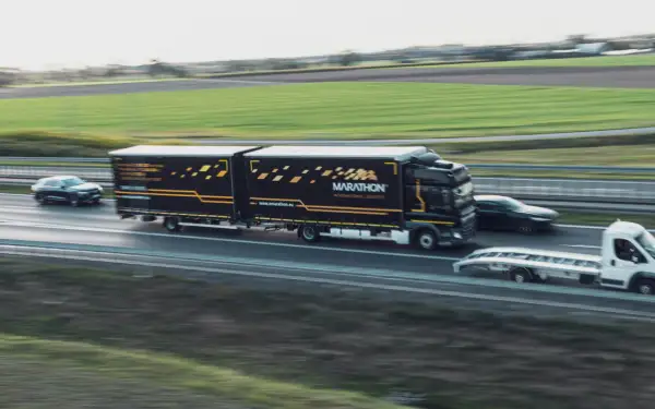 Ciężarówka Marathon International Logistics z naczepą jedzie autostradą. To część pakietu mobilności, który zapewnia sprawny transport.