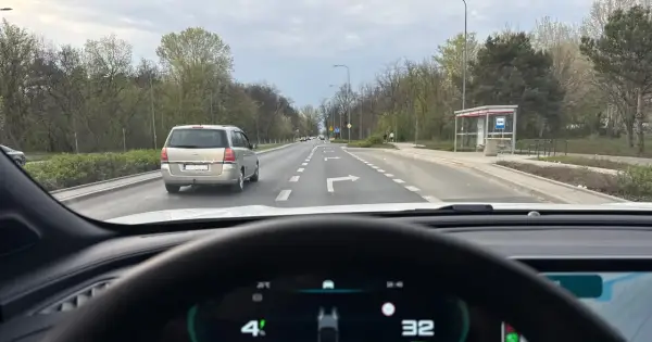 Jazda na suwak przepisy: samochód osobowy i minivan na drodze z pasami ruchu, jeden z nich wskazuje skręt w prawo.