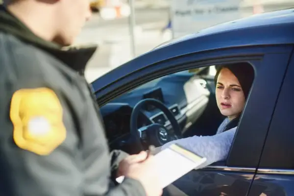 Policjant spisuje mandat kobiecie za przekroczenie ograniczenia prędkości w Austrii.